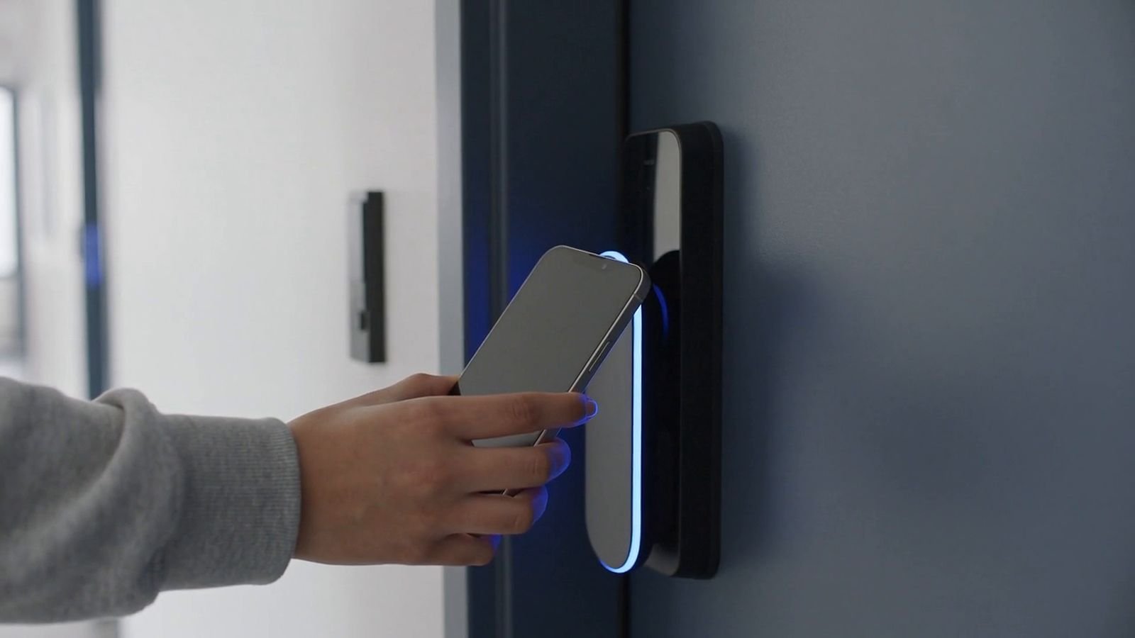 Student unlocking an apartment door with her phone (illustrative image)